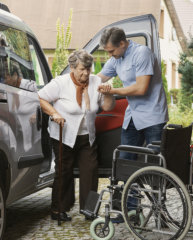 Caregiver assisting an elderly woman with transportation