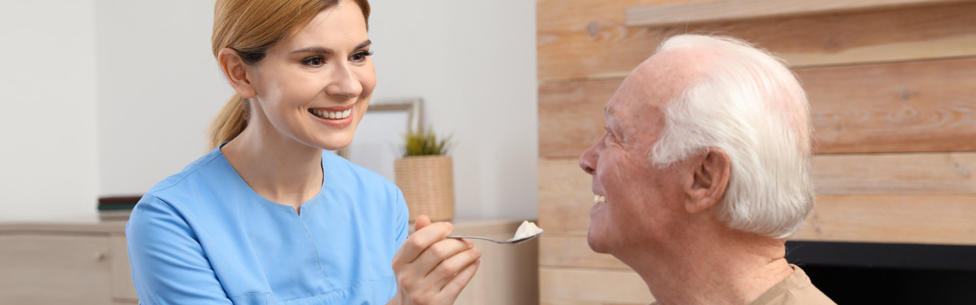 woman assist the elderly man to eat.